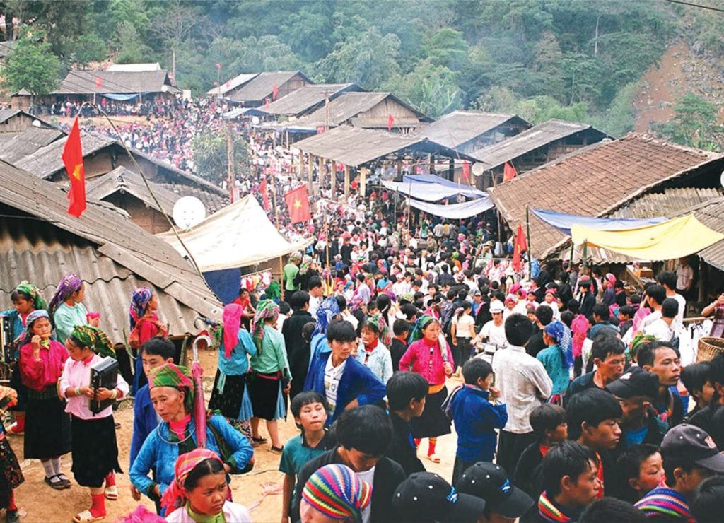 A vibrant crowd gathers at a village market in Ha Giang loop, showcasing local culture and a variety of market offerings.