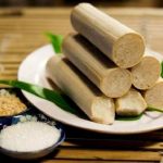 A plate of bamboo rice sticks accompanied by a small bowl of salt, showcasing traditional Vietnamese cuisine.